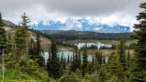 Snowy mountains with a lake at the bottom and cloudy sky