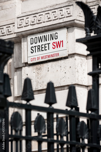 A road sign for Downing Street, the location of the residence of the Prime Minister, hangs on the wall in Whitehall, London photo