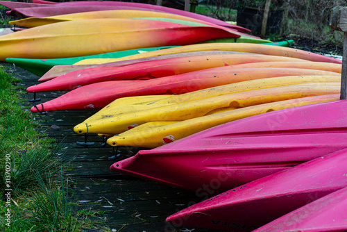 Group of canoes and rental kayak on the canal shore in Zoeterwoude, Leiden, Netherlands photo