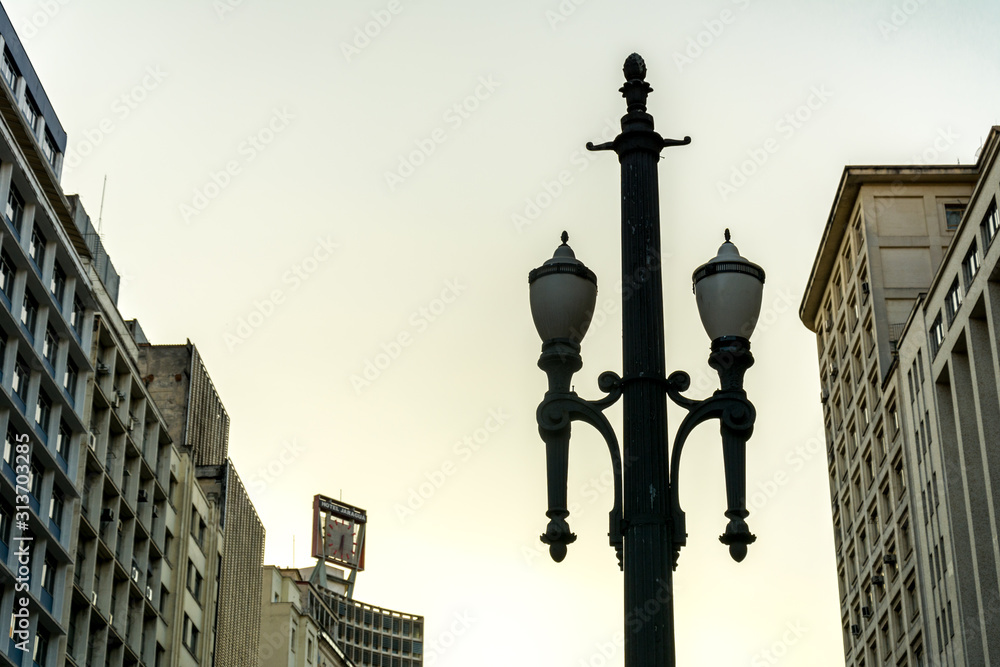 Old vintage street lamp, symbol of the downtown of the city of Sao Paulo, Brazil,  with some buildings.