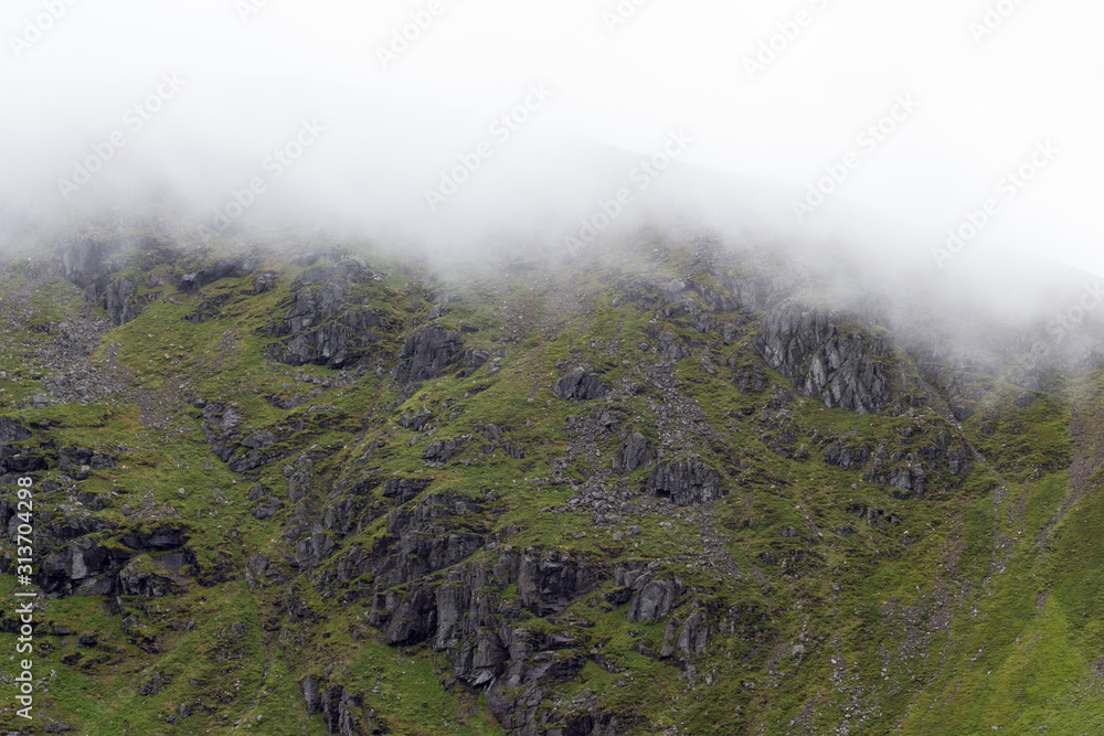 White cloud rolling down over rocky Scottish hillside