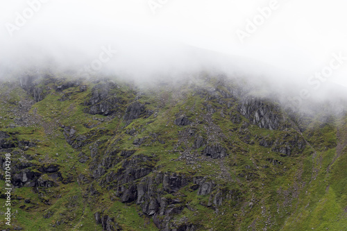 White cloud rolling down over rocky Scottish hillside © theteamtall
