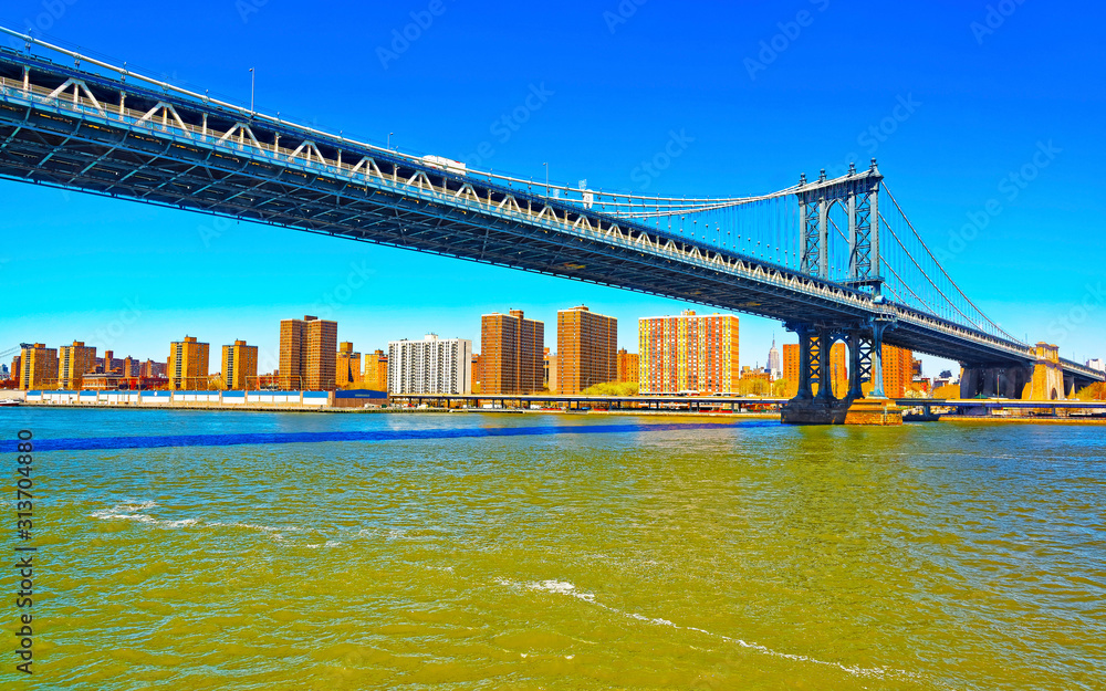 Obraz premium Manhattan bridge across East River, New York, USA. It is among the oldest in the United States of America. NYC, US. Skyline and cityscape. American construction
