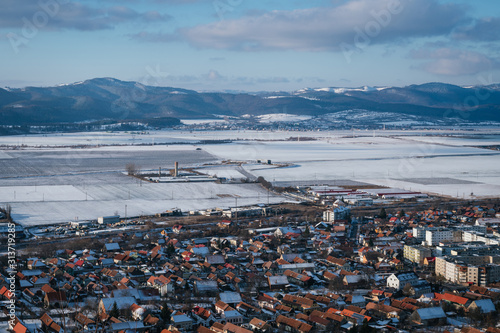Landscape of a European village with snowy fields in the background and with clear sky