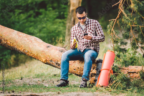 Eating banana Outdoors Hiking Trail. theme hiking and nature travel. Tourist take a rest and eating babanas. picnic in the forest. tourist eat snack food. Vitamin charge photo