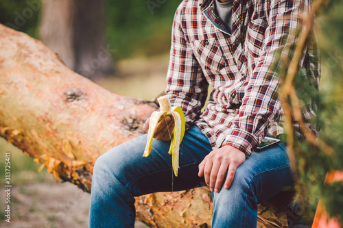 Eating banana Outdoors Hiking Trail. theme hiking and nature travel. Tourist take a rest and eating babanas. picnic in the forest. tourist eat snack food. Vitamin charge photo