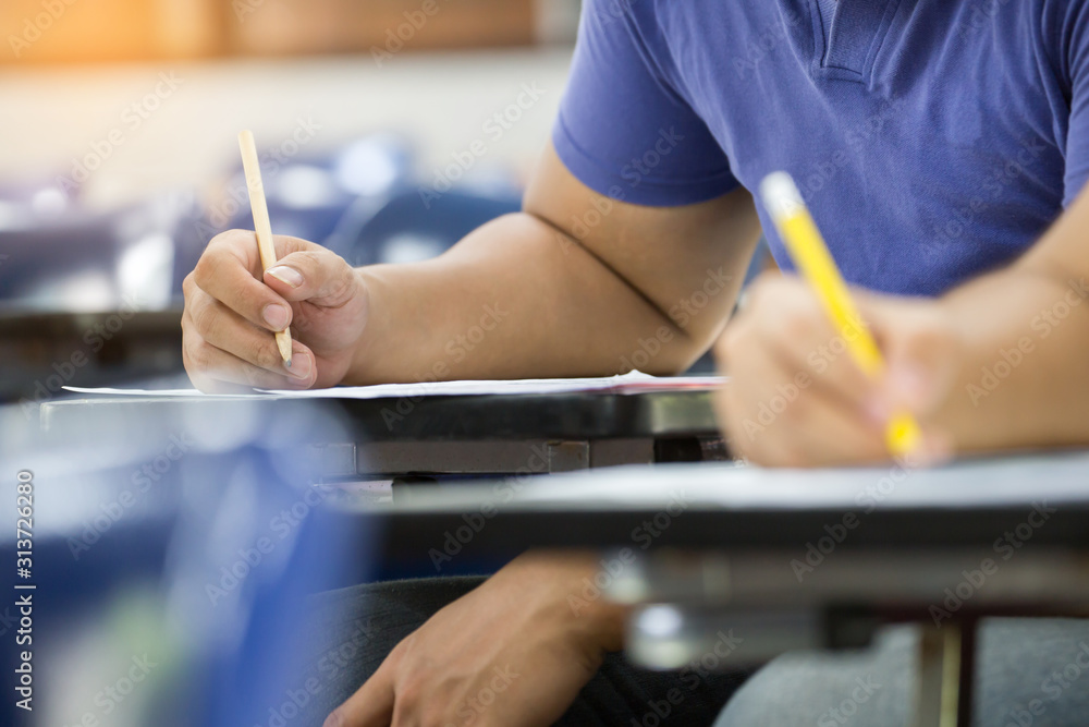 high school,university student study.hands holding pencil writing paper answer sheet.sitting lecture chair taking final exam attending in examination classroom.concept scholarship for education abroad high school,university student study.hands holding pencil writing paper answer sheet.sitting lecture chair taking final exam attending in examination classroom.concept scholarship for education abroad