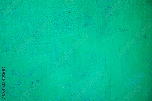 The texture of the iron wall, covered with green oil paint with traces of existence.