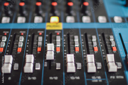 Musical control panel with sliders. Analog sound mixer or console. Remote control microphones and musical instruments.Buttons and tabs in various parts of the audio controller
