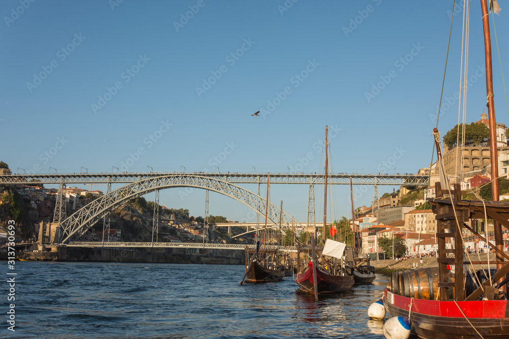 Oporto, Portugal - Douro river with traditional boats and Dom Luis iron bridge