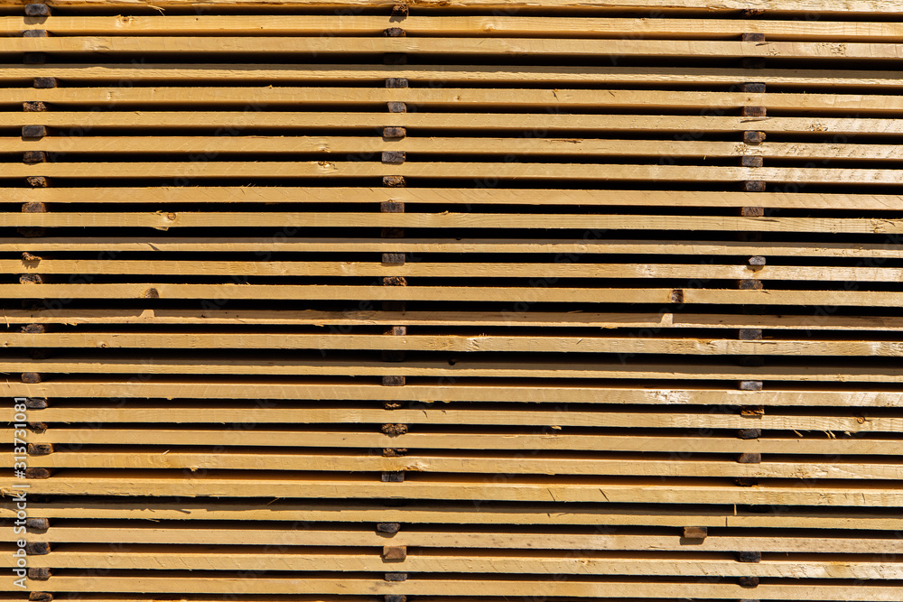 Close up and side view of a pallet filled with treated and milled pine wood planks. Natural building and construction industry materials filling frame. Close up and side view of a pallet filled with treated and milled pine wood planks. Natural building and construction industry materials filling frame.