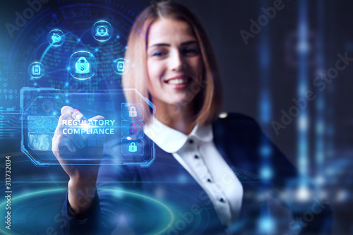 Business, technology, internet and networking concept. Young businessman working in the office, select the icon REGULATORY COMPLIANCE on the virtual display.