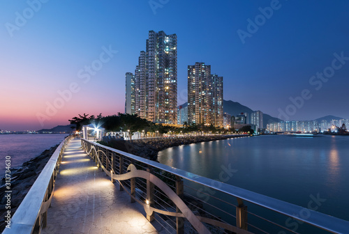 Seaside promenade and high rise residential building in Hong Kong city at dusk © leeyiutung