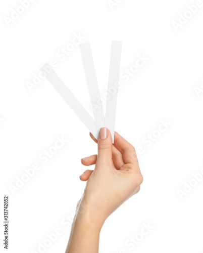 Woman holding perfume testing strips on white background, closeup photo