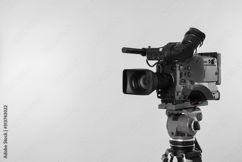 Modern professional video camera on light background. Space for text Modern professional video camera on light background. Space for text