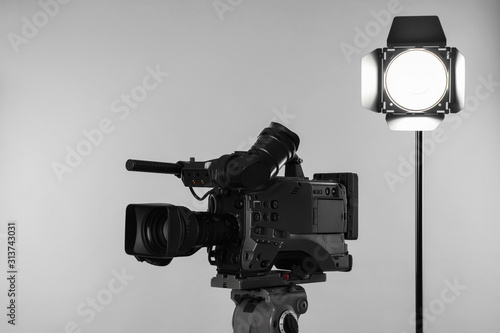 Professional video camera and lighting equipment on white background