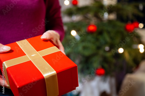 Frau Geschenk an Weihnachten for Christbaum übergeben / Frohe Weihnachten