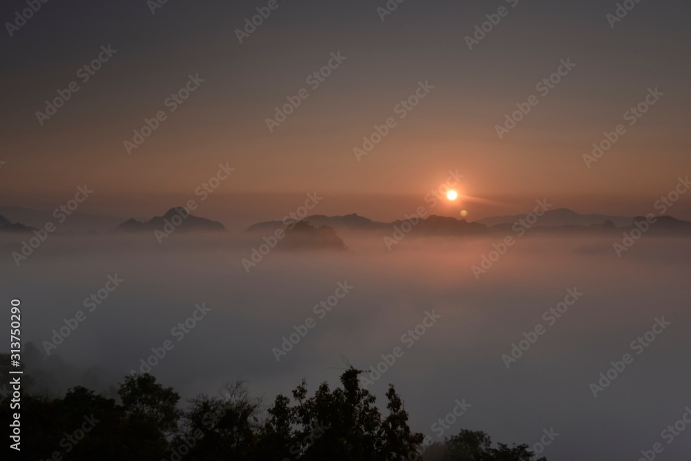 Sea of fog overwhelming a valley with sunrise sky in background