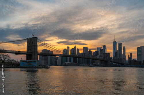 scene of New york Cityscape with Brooklyn Bridge over the east river at the sunset time, USA downtown skyline, Architecture and transportation concept © THANANIT