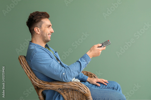 Handsome man watching TV wh...