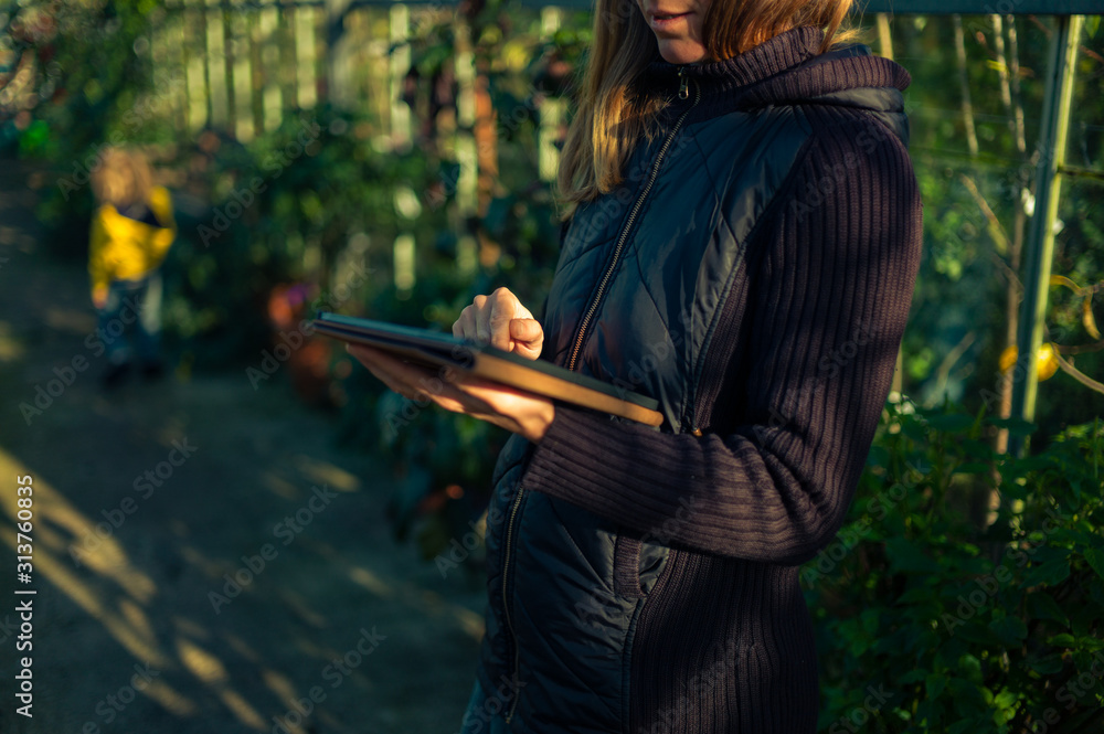 Young woman using tablet computer in greenhouse