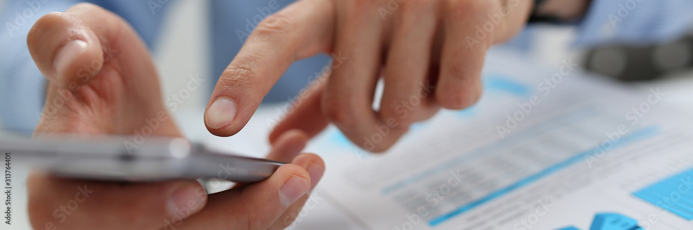 A businessman holds a new smartphone in his hand A businessman holds a new smartphone in his hand