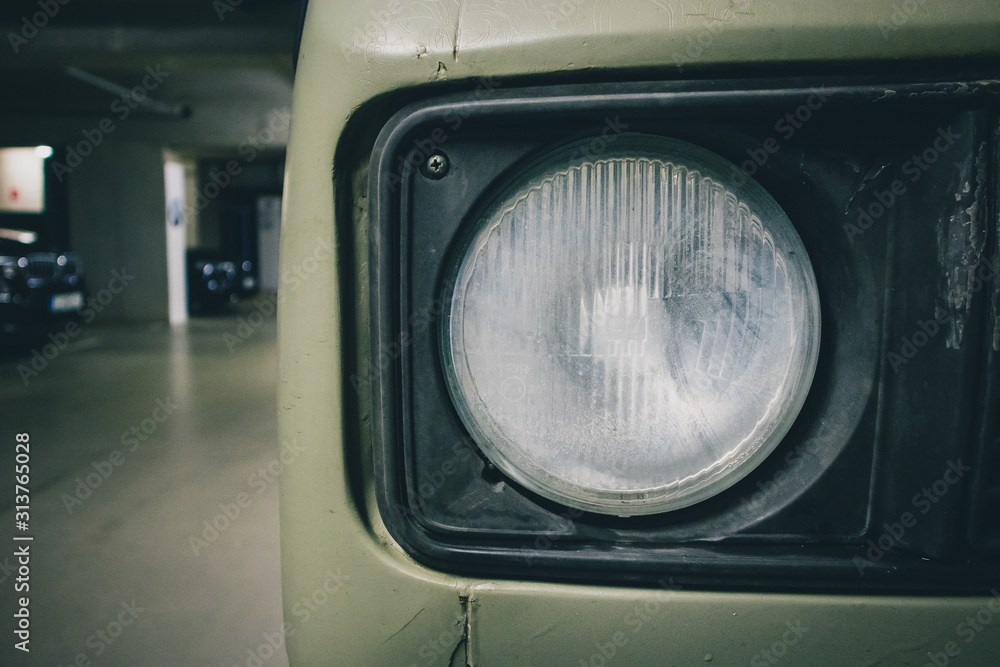 Hazy and worn out round head lamp on a van. Driving light in a poor condition that needs replacing. Foggy lamp, headlamp. Hazy and worn out round head lamp on a van. Driving light in a poor condition that needs replacing. Foggy lamp, headlamp.