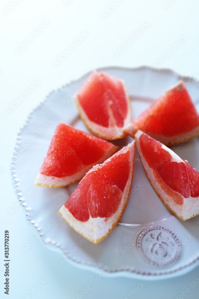 Cut fruit, red ruby grapefruit on dish for healthy dessert