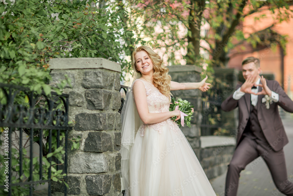 happy bride and groom doing a photo shoot on the street of the city happy bride and groom doing a photo shoot on the street of the city