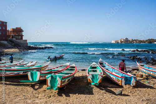 Fishing boats in Ngor Dakar, Senegal, called pirogue or piragua or piraga. Colorful boats used by fishermen standing in the bay of Ngor on a sunny day.