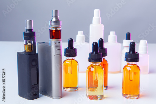 Vapes  liquids and white vials on the table. Smoking concept. Smoking electronic cigarettes. VAPE shop. Vaping. Vaper accessories.