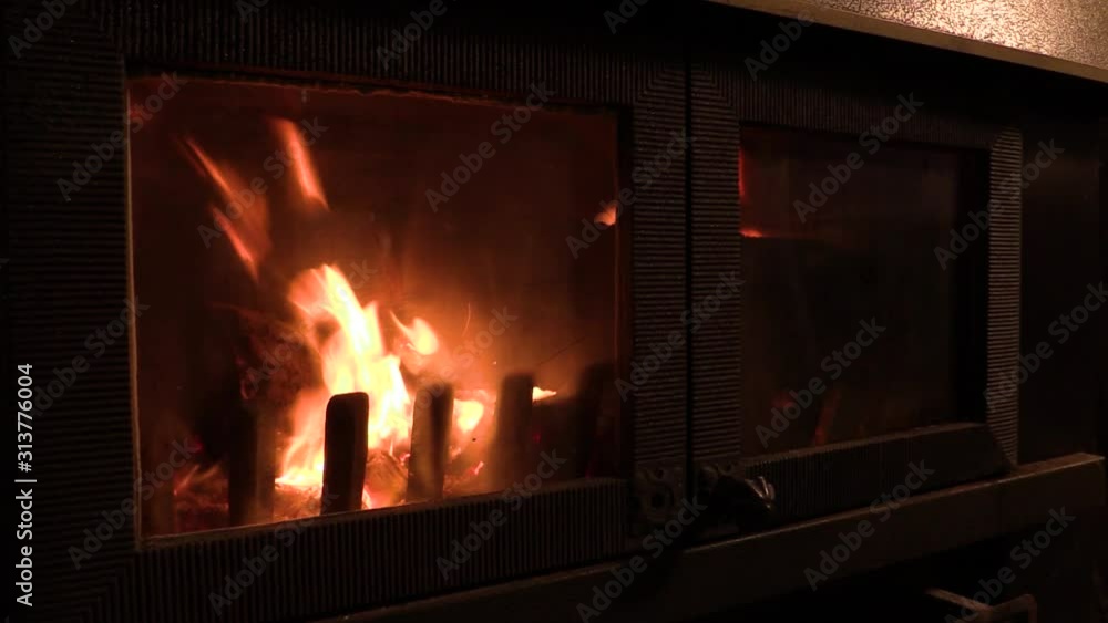 close-up of a wood-burning stove. view of flames in a wood burner. timber on fire in a stove at night. wood burning in the fireplace. Orange flames in the dark. close-up of a wood-burning stove. view of flames in a wood burner. timber on fire in a stove at night. wood burning in the fireplace. Orange flames in the dark.