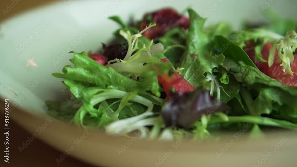 Fresh salad that is made up of fresh greens, local strawberries, and a light dressing. This was taken at a higher frame rate and has been converted to a slow motion video clip. Fresh salad that is made up of fresh greens, local strawberries, and a light dressing. This was taken at a higher frame rate and has been converted to a slow motion video clip.