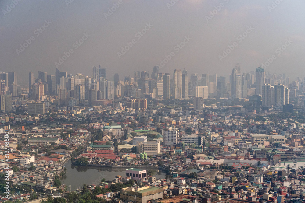 Aerial view of Manila skyscrapers through haze and smog