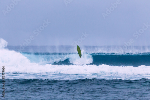 Valokuva Surfboard hovers over breaking wave after epic wipeout