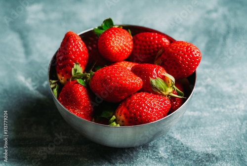 Ripe and juicy strawberries on the dark rustic background. Selective focus. Shallow depth of field.