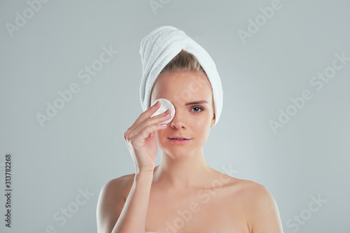 Healthy fresh girl removing makeup from her face with cotton pad. woman with a sponge wihte background cotton pad problem skin