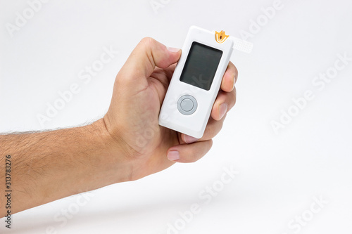 Wallpaper Mural Man holds in hand glucometer measures blood sugar level. Hand holding Blood Glucose Meter Torontodigital.ca