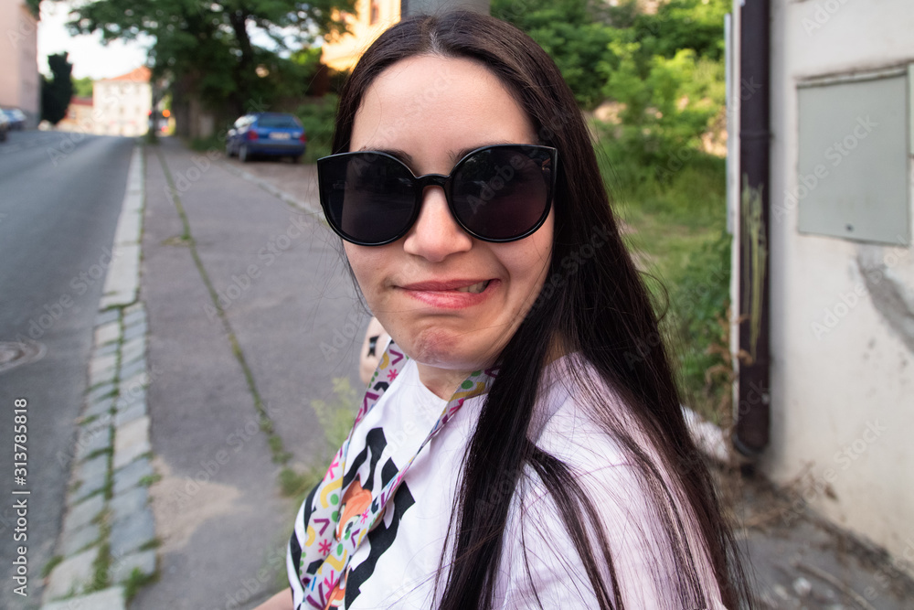 Young brunette in sunglasses with aversion expression. Woman with disgusted expression. Grimacing girl. Young brunette in sunglasses with aversion expression. Woman with disgusted expression. Grimacing girl.