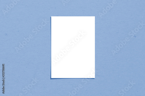 Blank white vertical paper sheet 5x7 inches with shadow overlay. Modern and stylish greeting card or wedding invitation mock up. Color of the year 2020 classic blue.