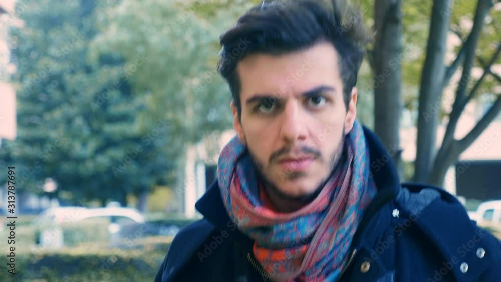 attractive serious man walking looking at camera - slow motion attractive serious man walking looking at camera - slow motion