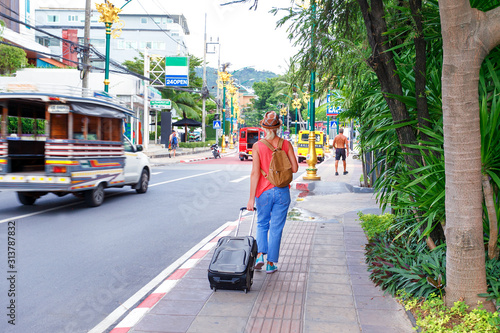  Woman walking with travel bag in Asia city street.