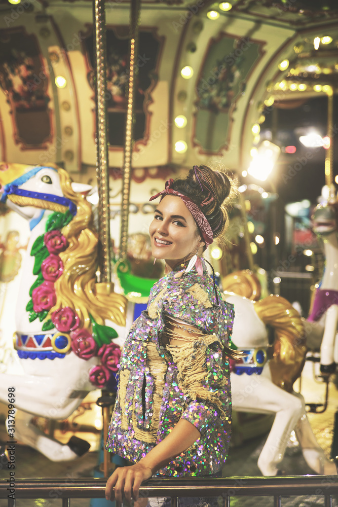 Stylish woman wearing sparkling jacket on the carousel