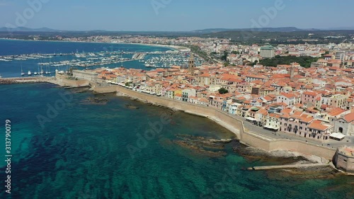 Aerial shot over Alghero old town, cityscape view on a beautiful day with harbor and open sea in view. Alghero, Italy. Panoramic aerial view of Alghero, Sardinia, Italy. photo