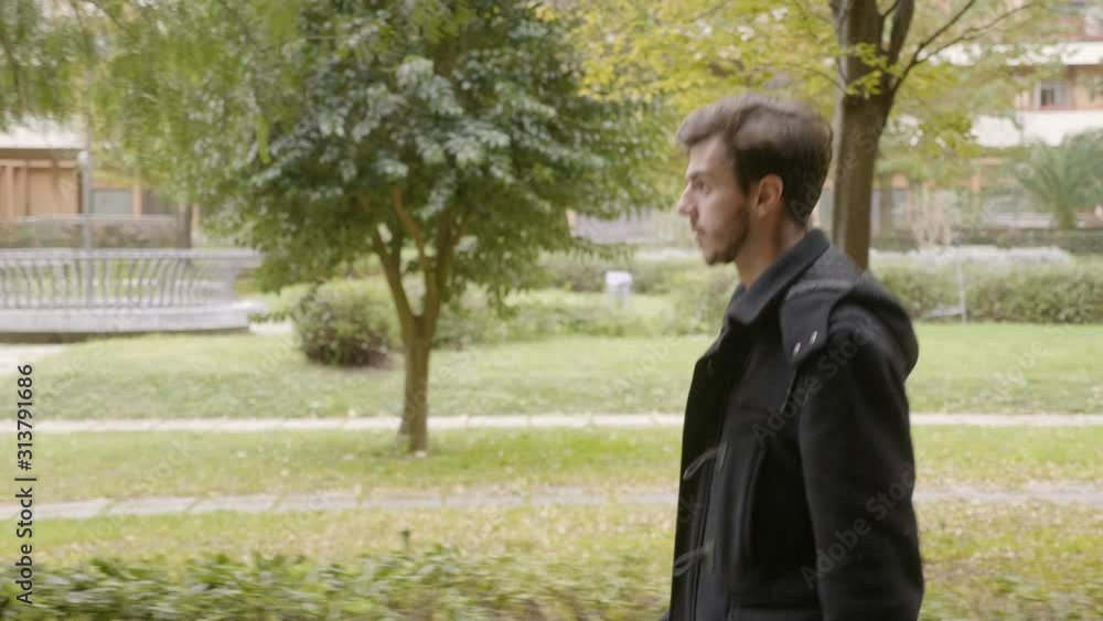 young handsome man walking alone looking straight ahead, slow motion young handsome man walking alone looking straight ahead, slow motion