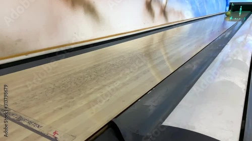 bowling ball rolls and knocks down pins