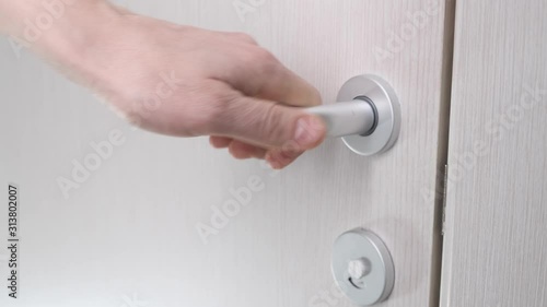 Person close wooden door bathroom with light. Slow motion.