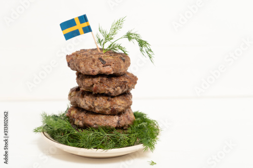 Traditional Swedish dish beef Lindstrom. In the plate with dill. Swedish flag.  Swedish cuisine. Scandinavian cuisine. photo