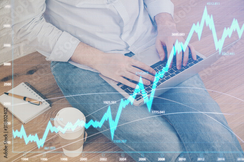 Forex graph with businessman working on computer in office on background. Concept of analysis. Double exposure.