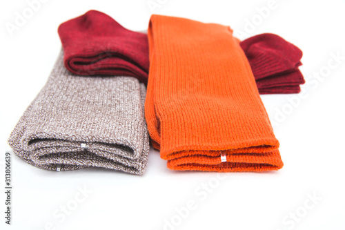 A set of stylish colorful multicolored man socks, lying one on another on white background. 23 February gift concept for the men. Side view. Selective focus.